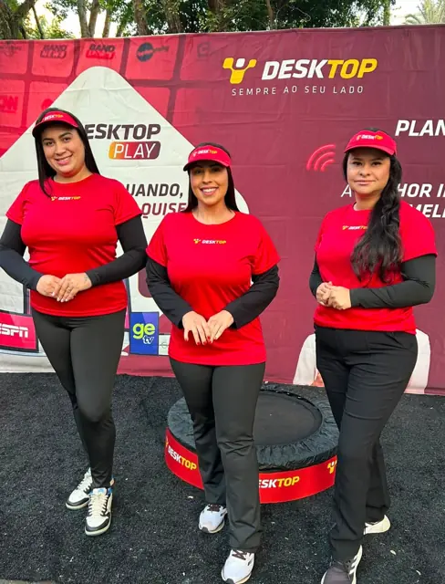 Três promotoras de uniforme vermelho no lançamento do Desktop Play